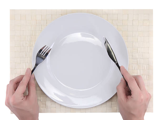 istock Hands hold fork and knife above plate. 178824773