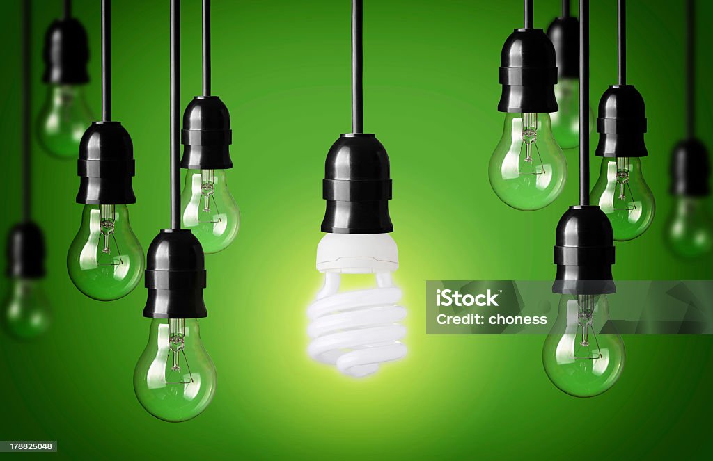 Eco concept with light bulbs on a green background glowing hanging energy saver light bulb and many other Cable Stock Photo