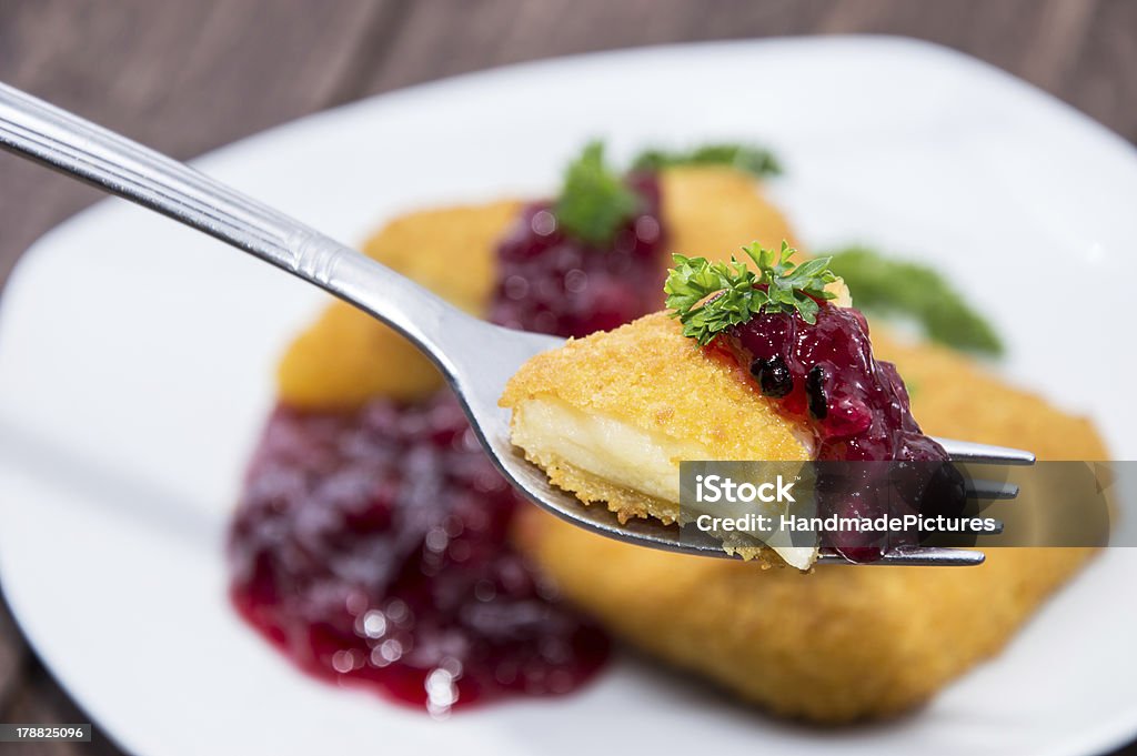 Fried Gouda on a fork Fried Gouda on a fork on wooden background Appetizer Stock Photo