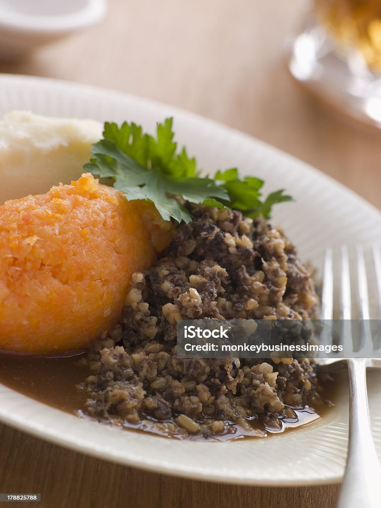 Plate of Haggis Neeps and Tatties Plate of Haggis Neeps and Tatties On White Plate With Silver Fork Haggis Stock Photo