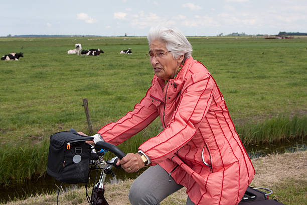 istock Elderly woman on a bicycle in Dutch polder 178826173