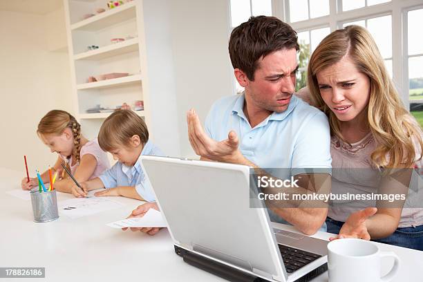 Young Couple Thinking And Looking At Laptop Computer Stock Photo - Download Image Now
