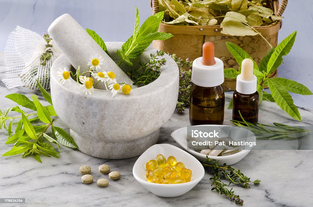 Alternative Medicine. Alternative Medicine. Rosemary, mint, chamomile, thyme in a marble mortar. Essential oils and herbal supplements. Homeopathic Medicine Stock Photo