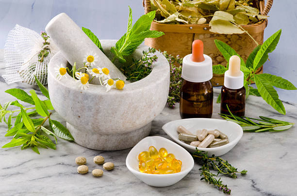 Alternative Medicine. Alternative Medicine. Rosemary, mint, chamomile, thyme in a marble mortar. Essential oils and herbal supplements. homeopathic medicine photos stock pictures, royalty-free photos & images