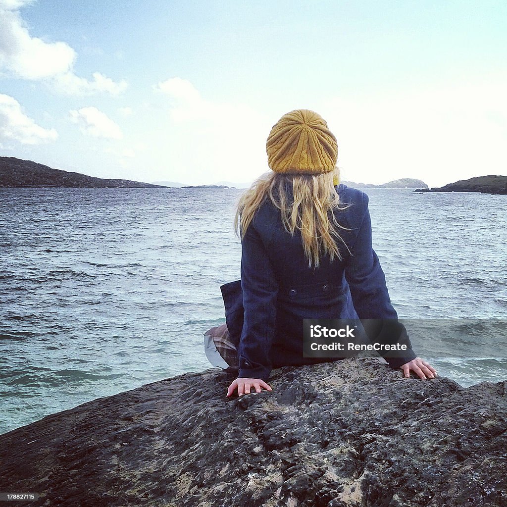 Girl Enjoying Life and Nature A girl sits on top of a cliff enjoying the nature in Ireland. Auto Post Production Filter Stock Photo