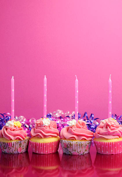 Pink birthday cupcakes with polka dot candles - vertical.