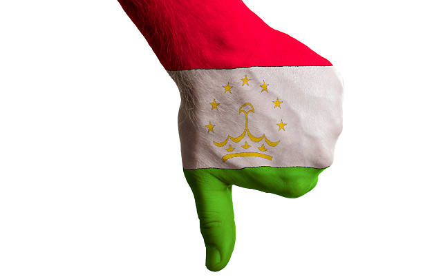 Hand with thumbs down gesture in colored tajikistan national flag as symbol of negative political, cultural, social management of country