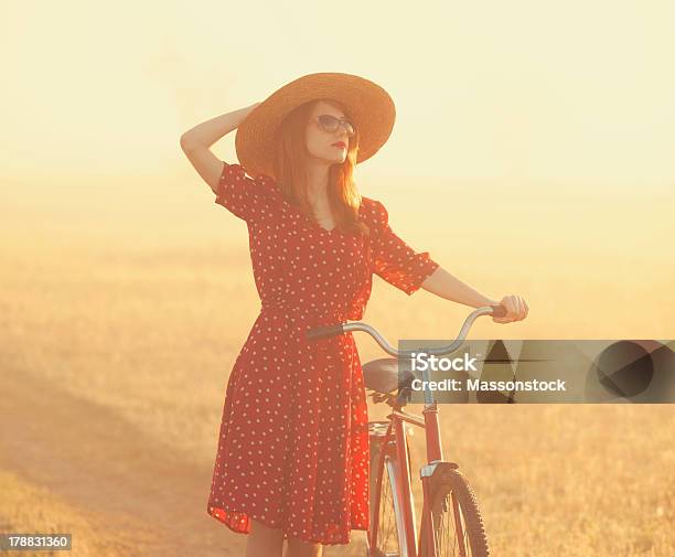 Girl On A Bike In The Countryside Stock Photo - Download Image Now - Adult, Adults Only, Agricultural Field