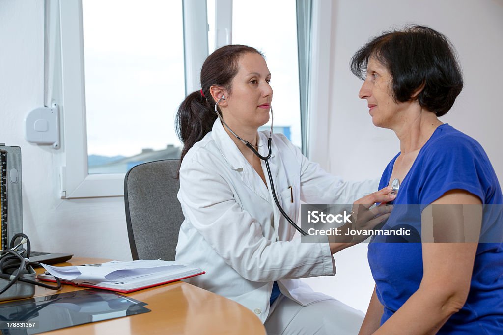 Young doctor examining her senior patient with a stethoscope Female doctor examining her patient 30-39 Years Stock Photo