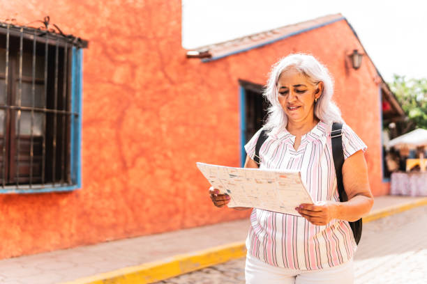 istock Senior tourist woman using a map while walking through the tourist town 1788317240