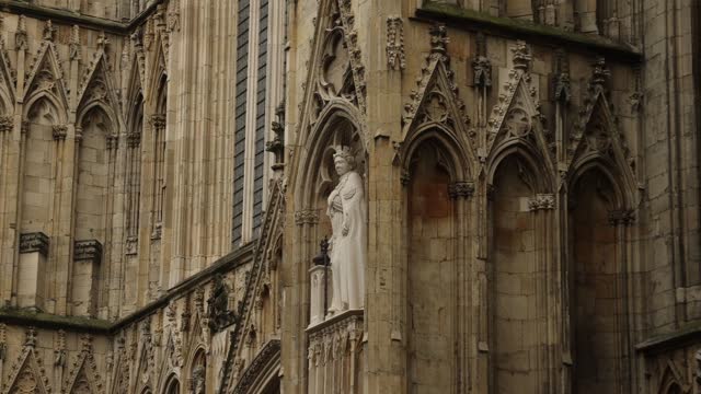 Hand-held shot of a Queen Elizabeth statue on York Minster, England