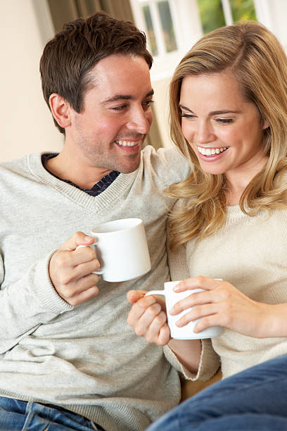 istock Young couple sitting and relaxing on sofa with cup 178832741