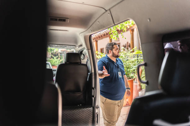 istock Private tour guide opens the van door for tourists to enter 1788327842