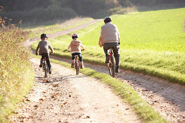 istock Young father with children ride bikes in park 178832803