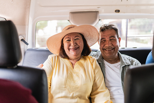 Portrait of traveler senior tourist couple inside a tour van