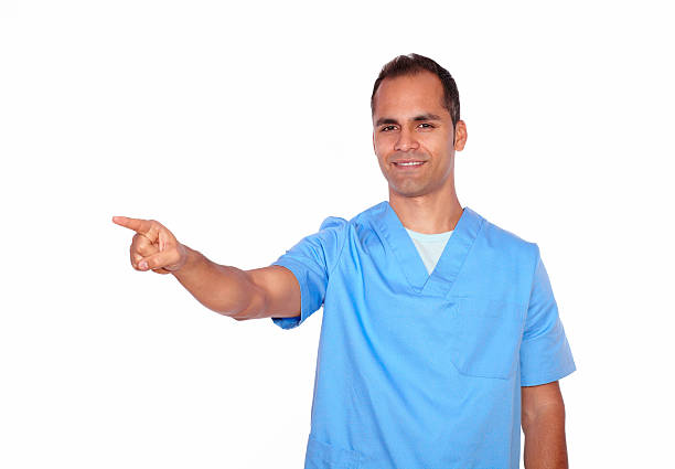 istock Smiling nurse in uniform pointing to his right 178833824