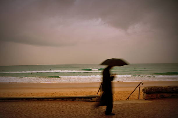 istock Man in black suit with umbrella 178834578