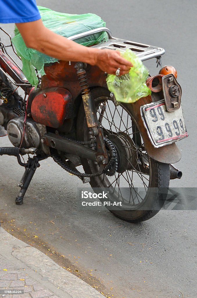 Fixing Motorbike Chain That Came Off The chain came off as this person turned around a corner. He than pulled aside to fix the problem using a plastic bag to not get dirty. Broken Stock Photo