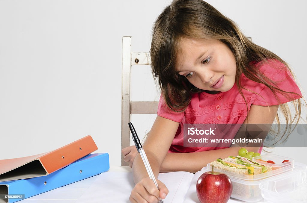 Jovem Menina o seu trabalho de casa na tabela - Royalty-free Alimentação Saudável Foto de stock