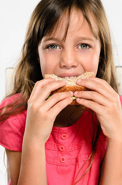 istock School girl eating her packed lunch sandwich 178835690
