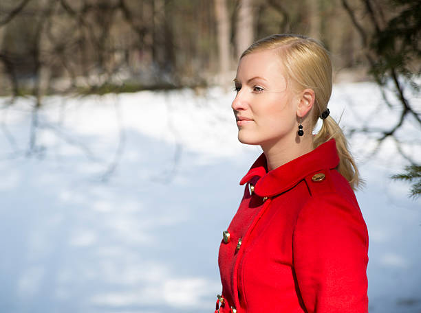 Young beautiful woman walking in a park and breathing fresh winter air and feeling wonderful. Model plus size