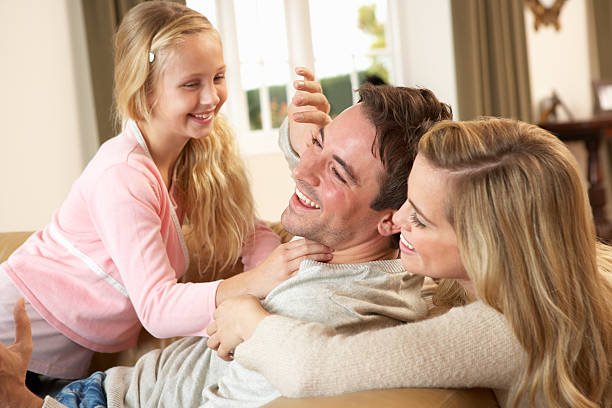istock Happy young family playing together on sofa 178839428