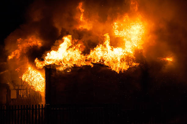 Burning fire flame on wooden house roof stock photo