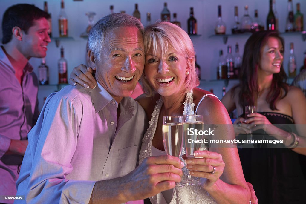 Coppia Senior divertendosi nel Bar occupato - Foto stock royalty-free di Happy Hour