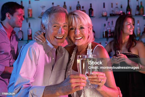Coppia Senior Divertendosi Nel Bar Occupato - Fotografie stock e altre immagini di Happy Hour - Happy Hour, 60-69 anni, Abbracciare una persona