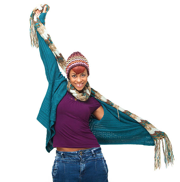 Portrait of a young African American woman wearing winter clothes and holding her arms out. Isolated on white