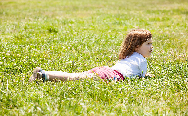 istock 3 years girl on grass 178843729