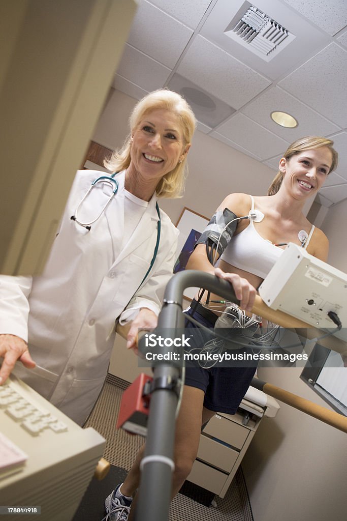 Medico di monitorare la frequenza cardiaca del paziente su un tapis roulant - Foto stock royalty-free di Tapis roulant