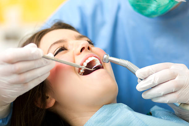 A young woman at the dentist office Dentist doing dental treatment to a woman looking in mirror stock pictures, royalty-free photos & images