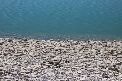 Rocky lake shore with teal water