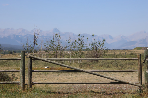 Wooden fence in front of field and mountains