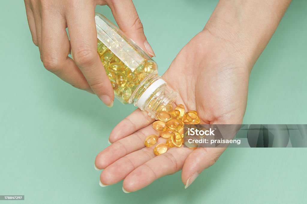 Mão da mulher. Pegue a vitamina ômega 3 pílulas Óleo de peixe - Foto de stock de Alimentação Saudável royalty-free