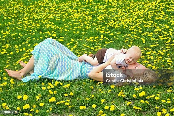 Mother Kissing Baby In Dandelion Field Stock Photo - Download Image Now - Family, Lying Down, Moving Down