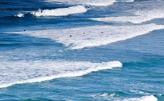 Lapiz lazuli and steel blue waters at Point Danger with surfers! Queensland New South Wales border