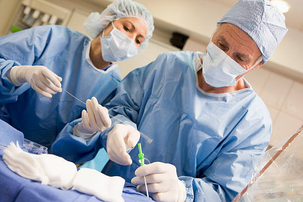 Surgeons Preparing Equipment For Surgery Surgeons Preparing Equipment For Surgery Wearing Hospital Mask Concentrating heart surgery photos stock pictures, royalty-free photos & images