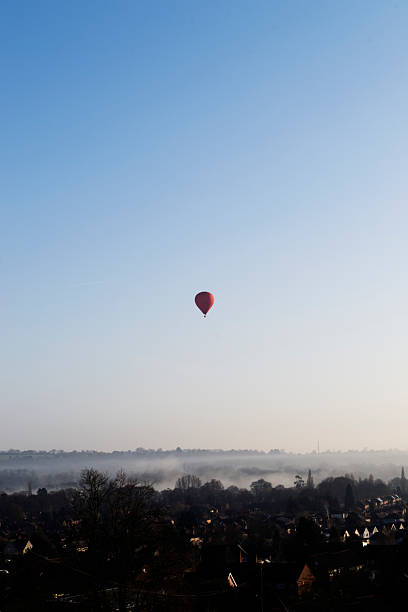 istock Hot air balloon rising over a misty town 178849488