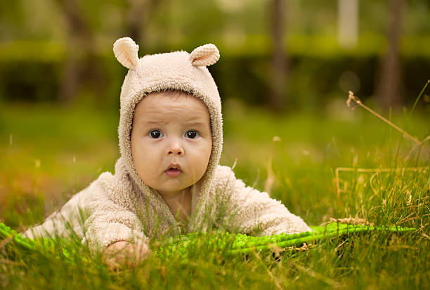 istock little girl sitting on green grass 178849972