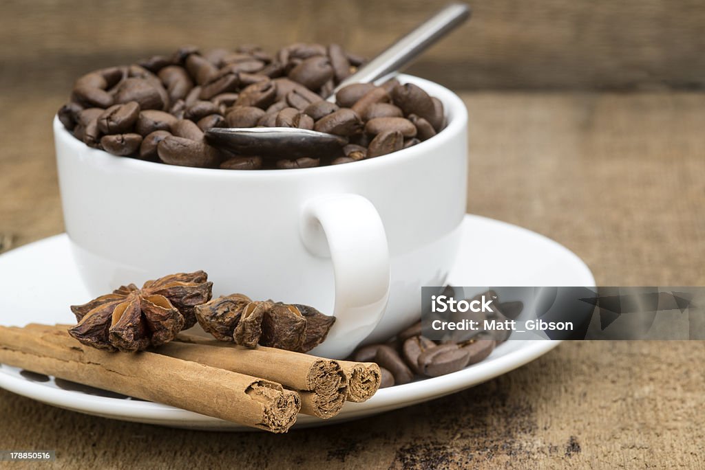 Cup of coffee and beans on wooden background Cup of coffee and beans with cinnamon sticks and star anise on wooden background Africa Stock Photo