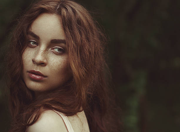 Young woman with red hair outdoors portrait. Soft sunny colors. stock photo