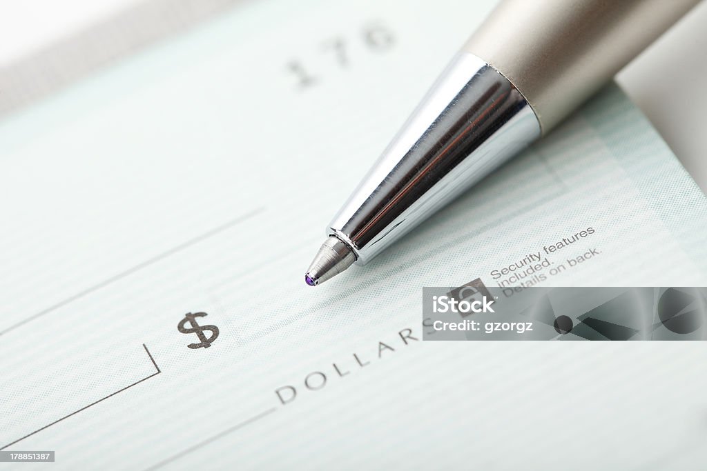 Writing A Check Close up photo of a pen and blank dollar check. Shallow focus Check - Financial Item Stock Photo