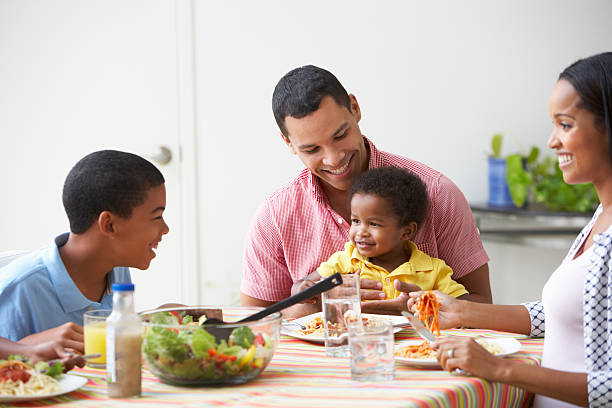 famille de manger des repas ensemble à la maison - child eating pasta spaghetti photos et images de collection