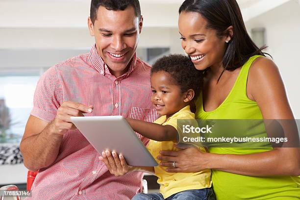 Man Woman And Child Using A Tablet In A White Room Stock Photo - Download Image Now