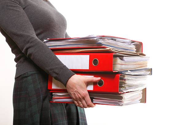 istock Female office worker carrying a stack of files 178853859