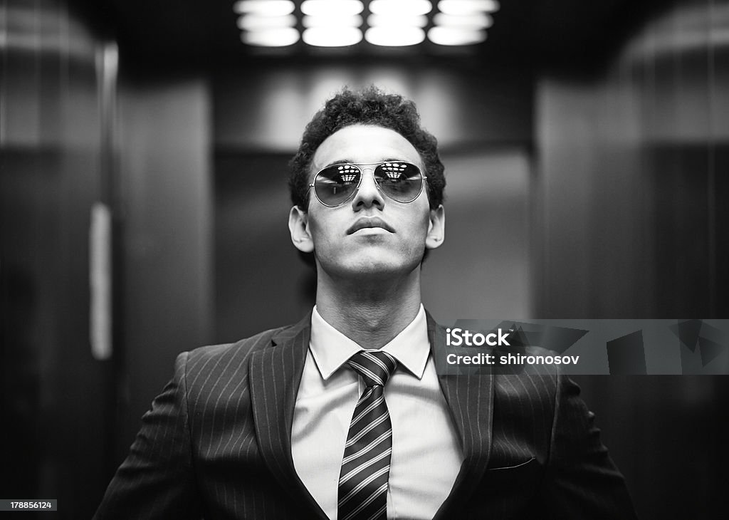 Ambitious Black-and-white portrait of an ambitious business guy wearing sunglasses Adult Stock Photo