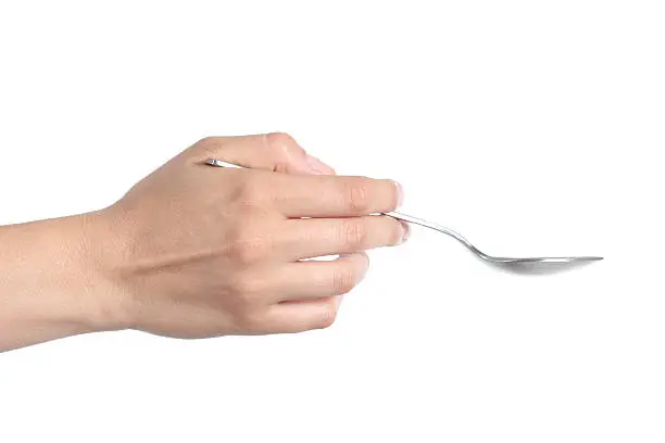 Profile of a woman hand using a spoon isolated on a white background