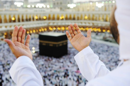 Rezar musulmana en Mekkah con las manos arriba photo